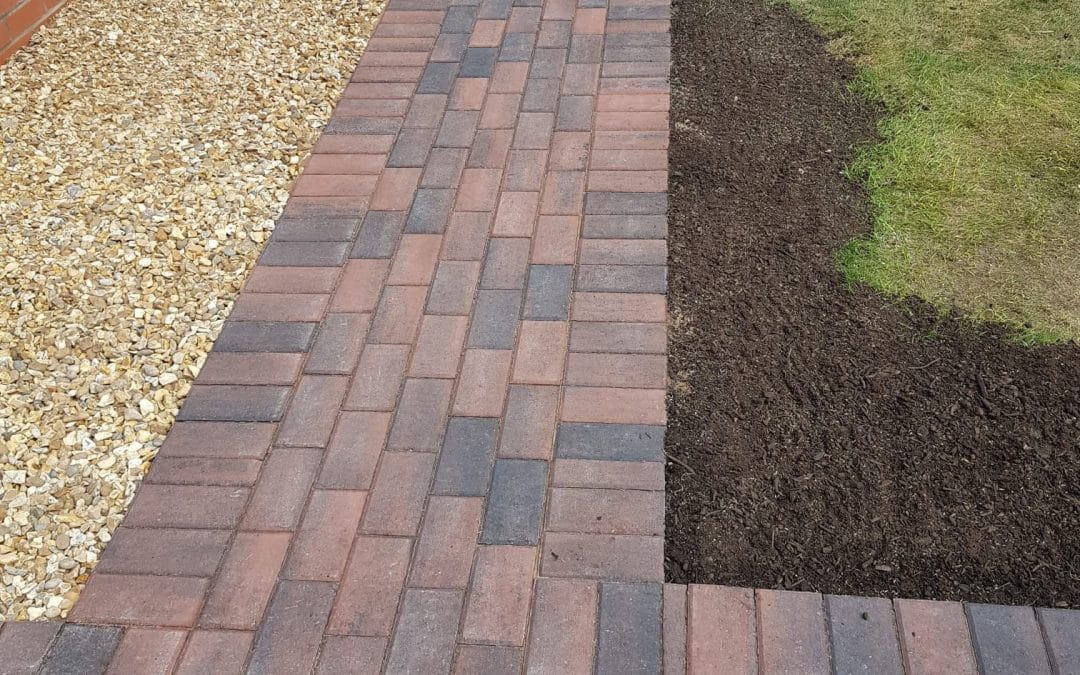 Garden landscaping project showing partially completed turf installation